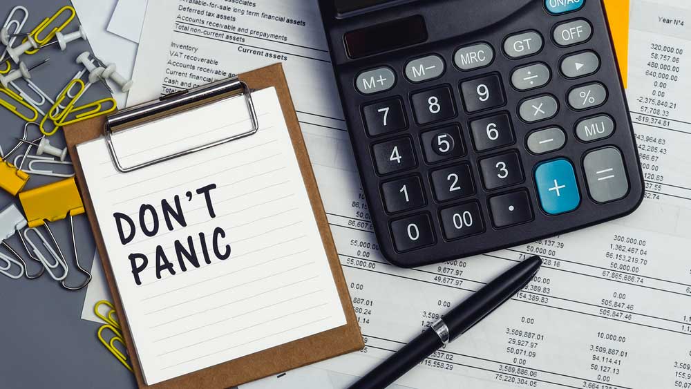 don't panic written on clipboard with calculator adding up energy bills