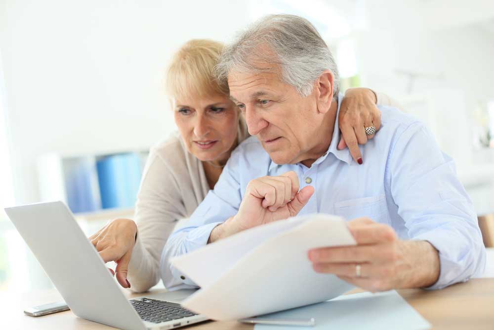 older mature couple looking at their energy bills