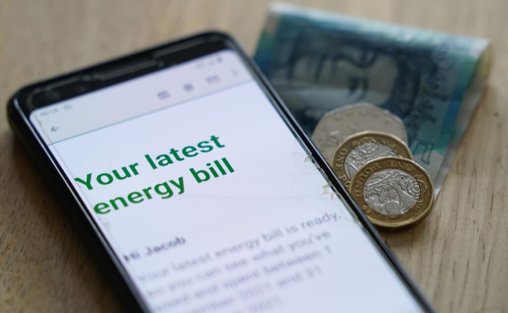 phone showing energy bill beside money